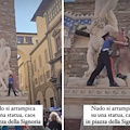 Firenze, uomo nudo si arrampica su statua in piazza della Signoria: sul corpo la scritta "censurato"