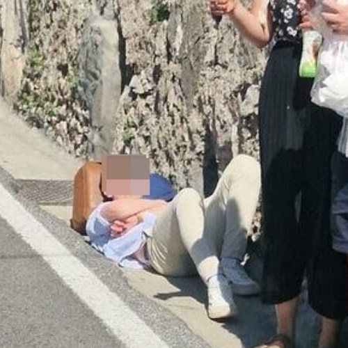 turista aspetta bus disteso sul ciglio della strada